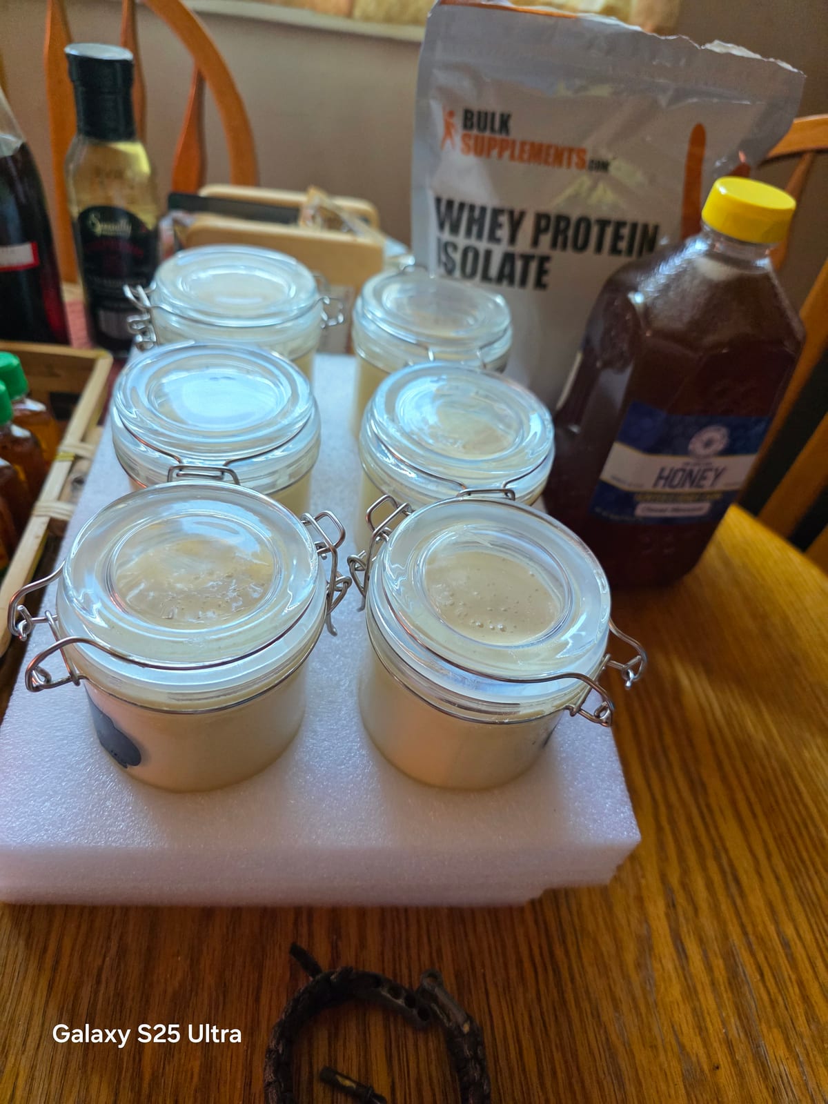 Six sealed jars with the honey bottle and whey bag